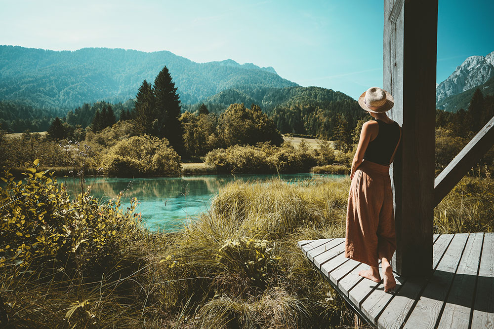 Femme admirant un lac et des montagnes